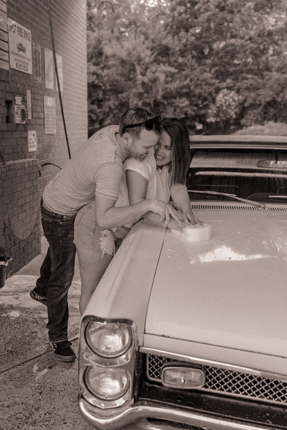 Couple being playful during a couples car wash lifestyle session