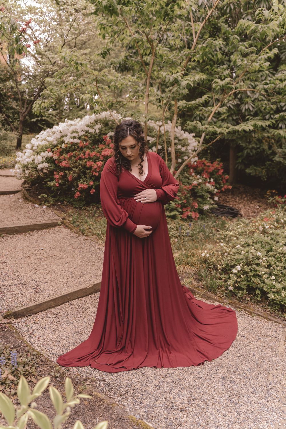 pregnant mother looking at her baby bump during maternity lifestyle session at UNCC Gardens in Charlotte, North Carolina