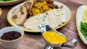 Assorted Mediterranean mezze dishes with hummus, pita bread, olives and roasted vegetables on a rustic wooden table.