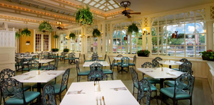 Bright yellow dining room with multiple ceiling fans, white trim, and blue dining chairs set for elegant dining service.