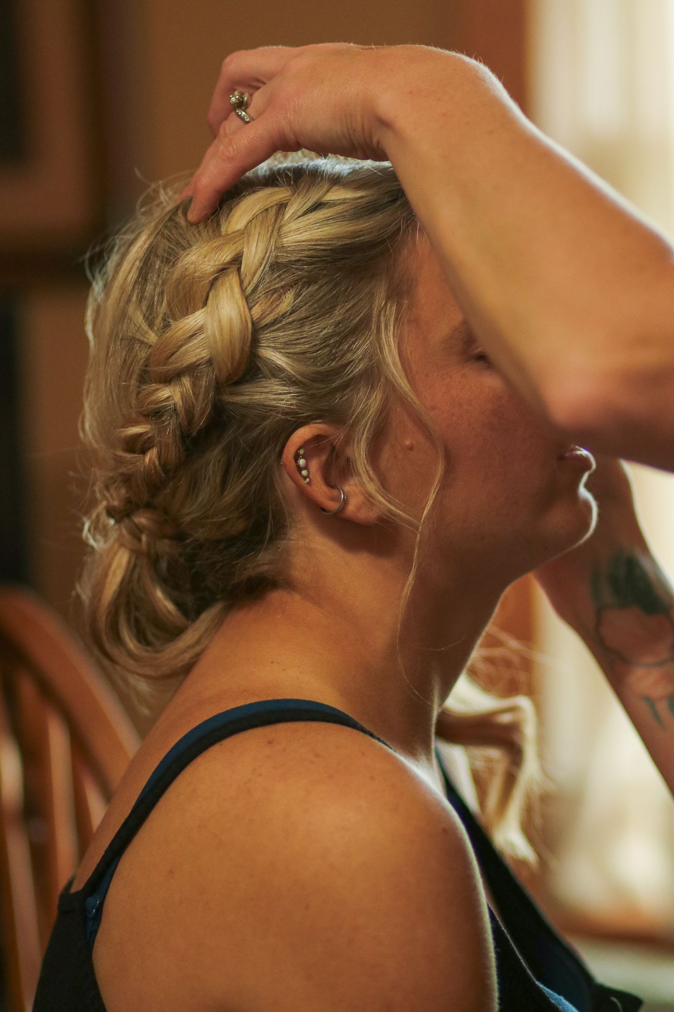 Close-up of an intricate braided hairstyle being styled for a special occasion.