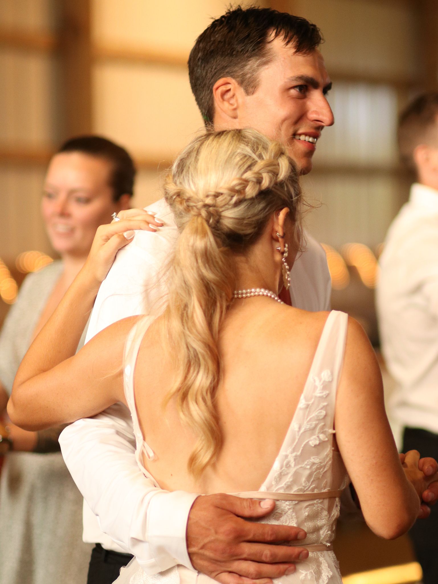 A romantic wedding dance moment shows a couple smiling and embracing on the dance floor.