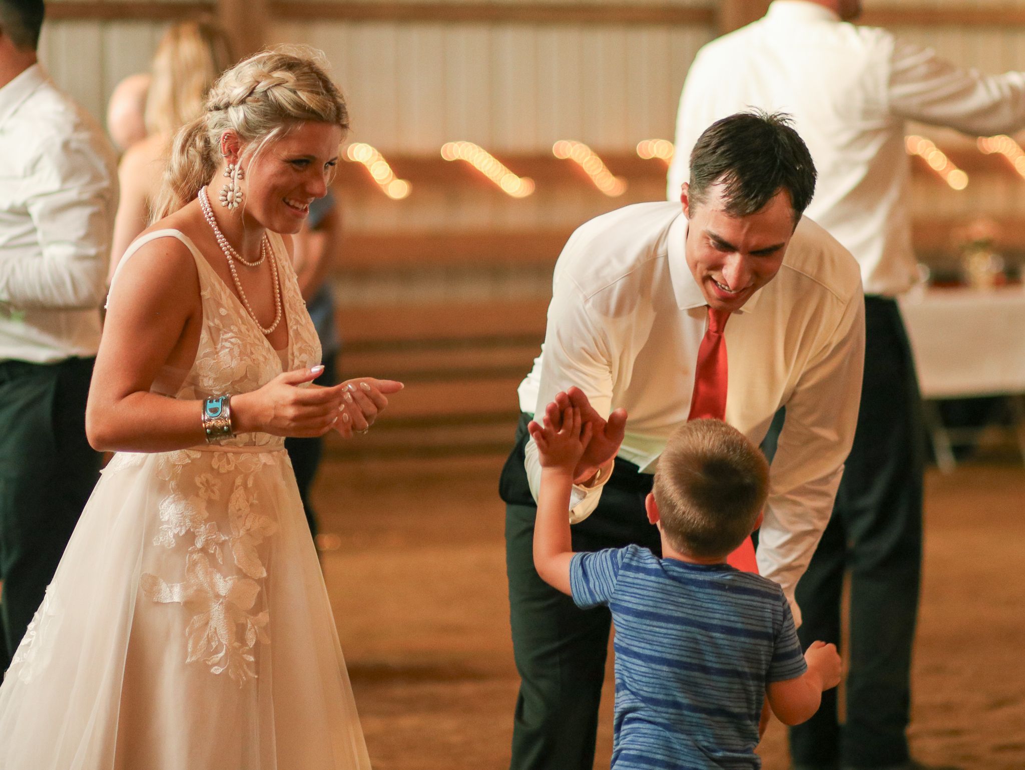 A dance moment at a wedding reception with a young child joining in.