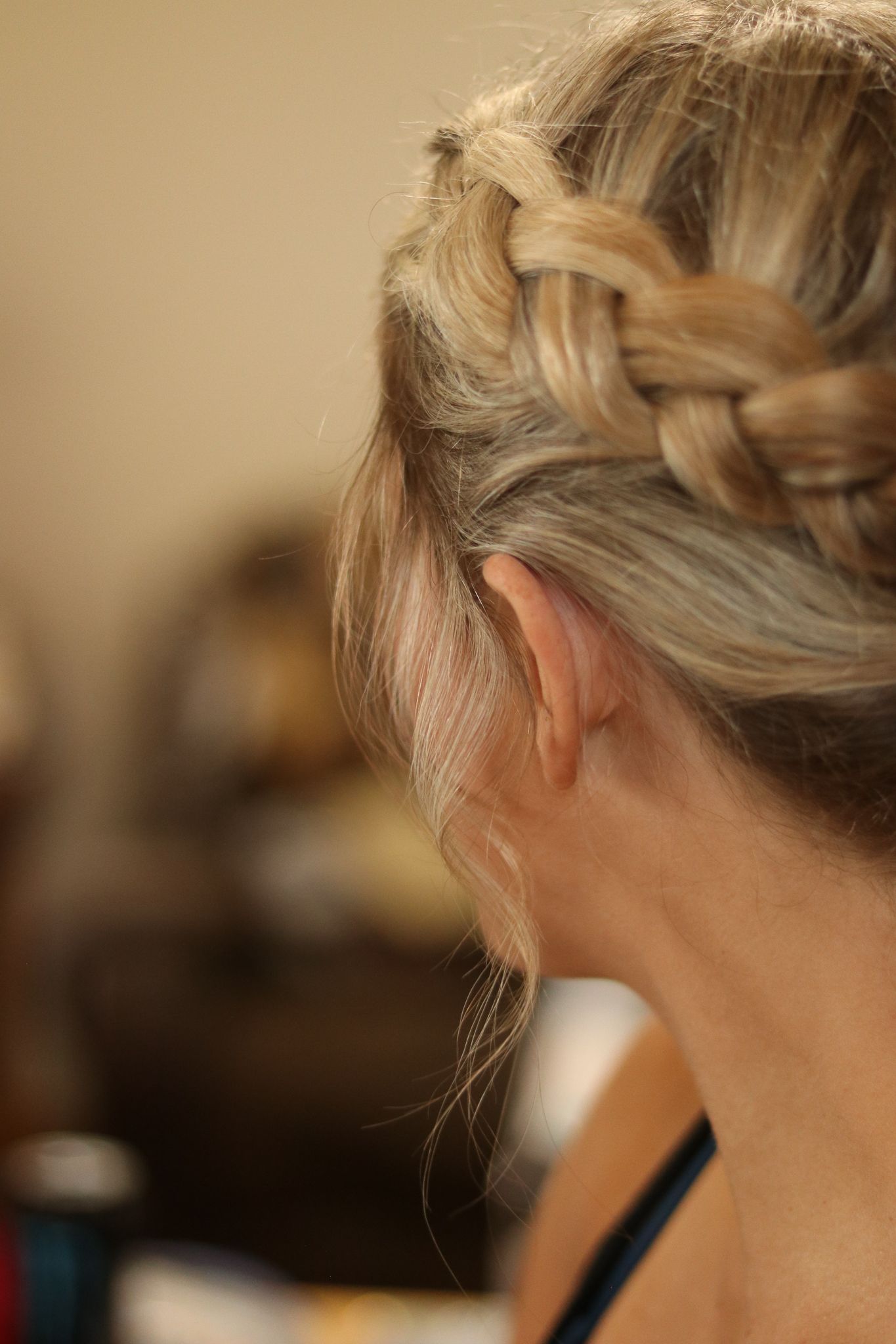 Close-up side view of an intricate French braid hairstyle in blonde hair.