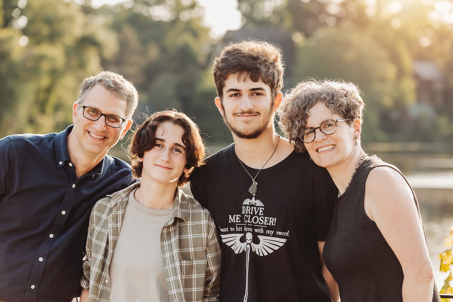 Group photo outdoors with sunny backlighting and casual attire in a natural setting.