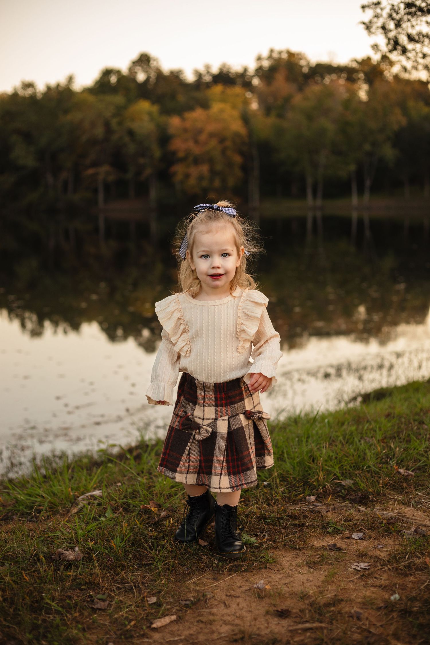 Harrisonburg photographer, family, newborn, maternity, baby, little girl in plaid skirt against fall lake and treeline