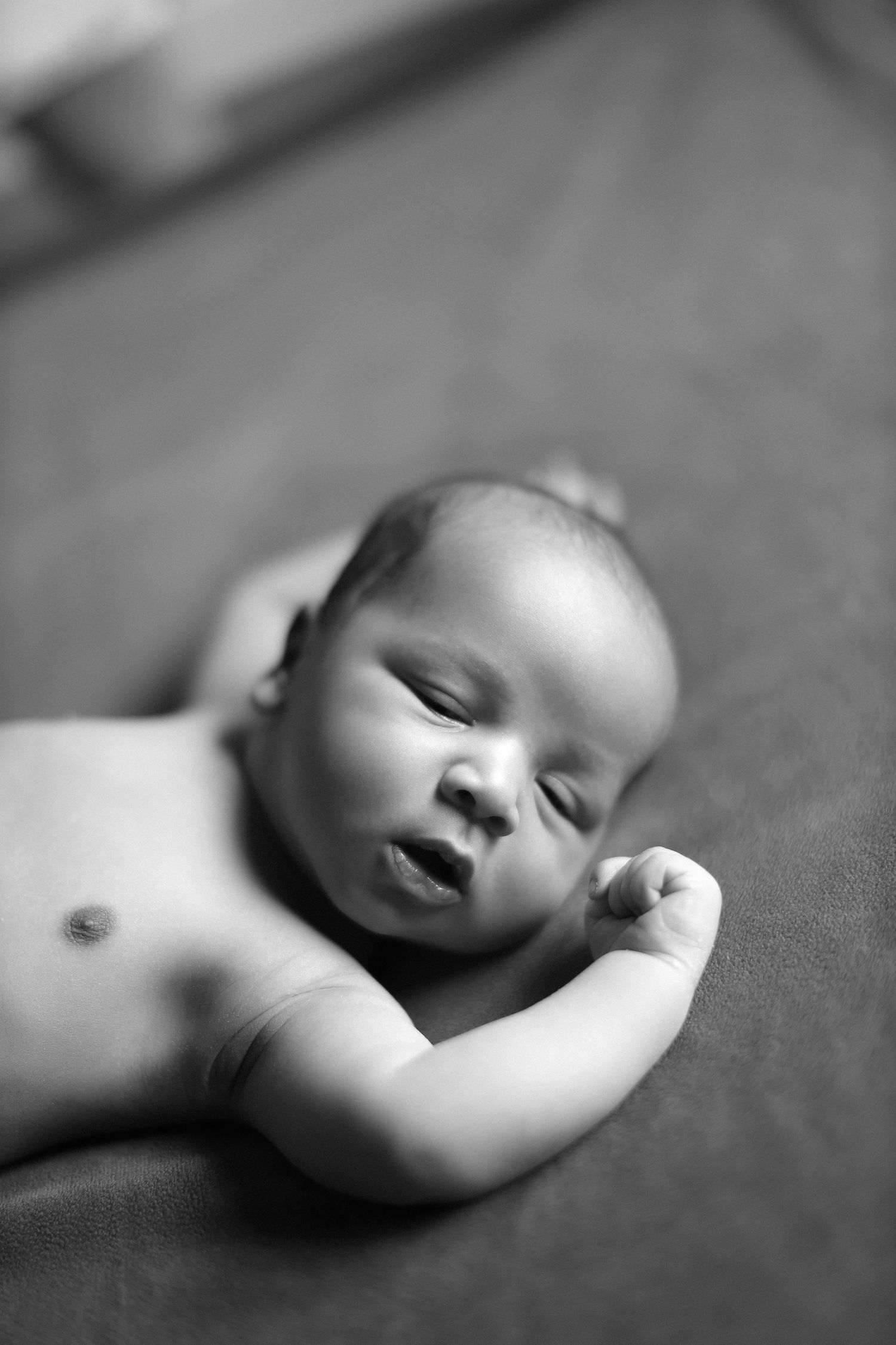 Black and white close-up portrait of peaceful sleeping newborn baby.