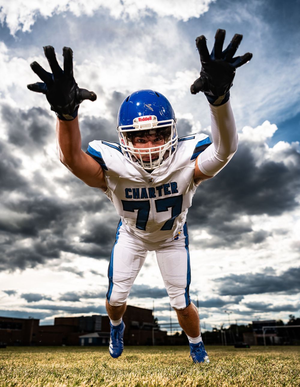 Dynamic sequence of four shots showing a football player in white uniform making energetic jumping poses against cloudy sky.