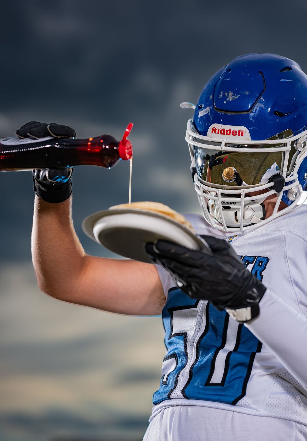 Football players in blue and white uniforms compete for possession during intense game play.
