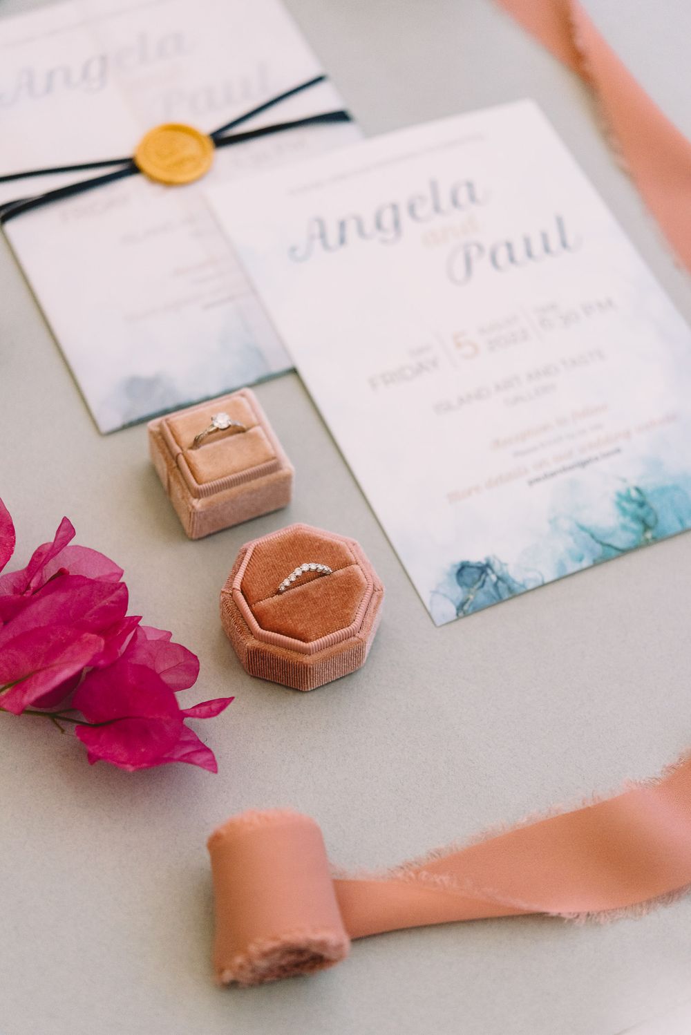 Wedding stationery suite for Angela and Paul with watercolor invitations, wax seal, diamond rings in velvet box, and pink ribbon.