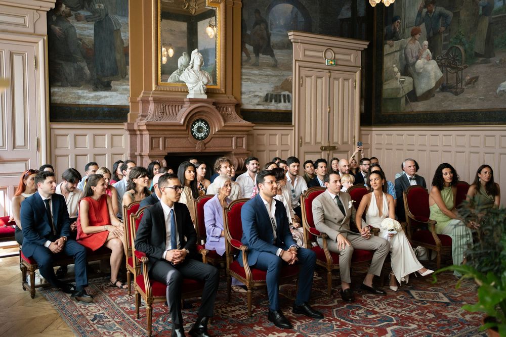 Wedding guests seated in elegant room with ornate decor during a ceremony at paris city hall, paris civil ceremony, paris wedding ceremony