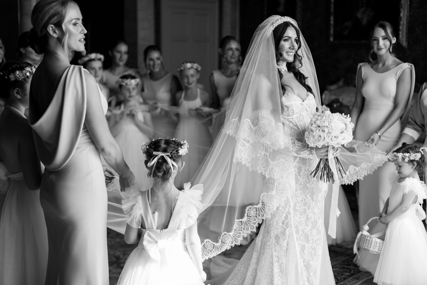 Ethereal bridal portrait with soft tulle veil and sparkly earrings in romantic lighting.