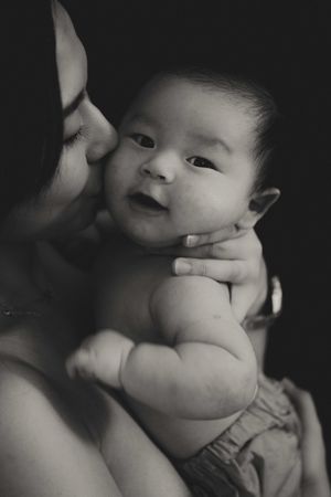Black and white close-up photo series showing a baby's chubby cheeks and hands in different playful poses.一組黑白特寫照片，展現了嬰兒胖乎乎的臉頰和小手擺出的各種俏皮姿勢。