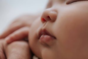 A close-up macro photograph shows a person's lips and nose against a soft blurred background.一張特寫微距照片顯示了人的嘴唇和鼻子，背景是柔和的模糊效果。