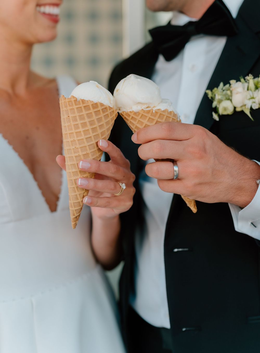 Bride and groom toasting with vanilla ice cream waffle cones at their wedding reception.
