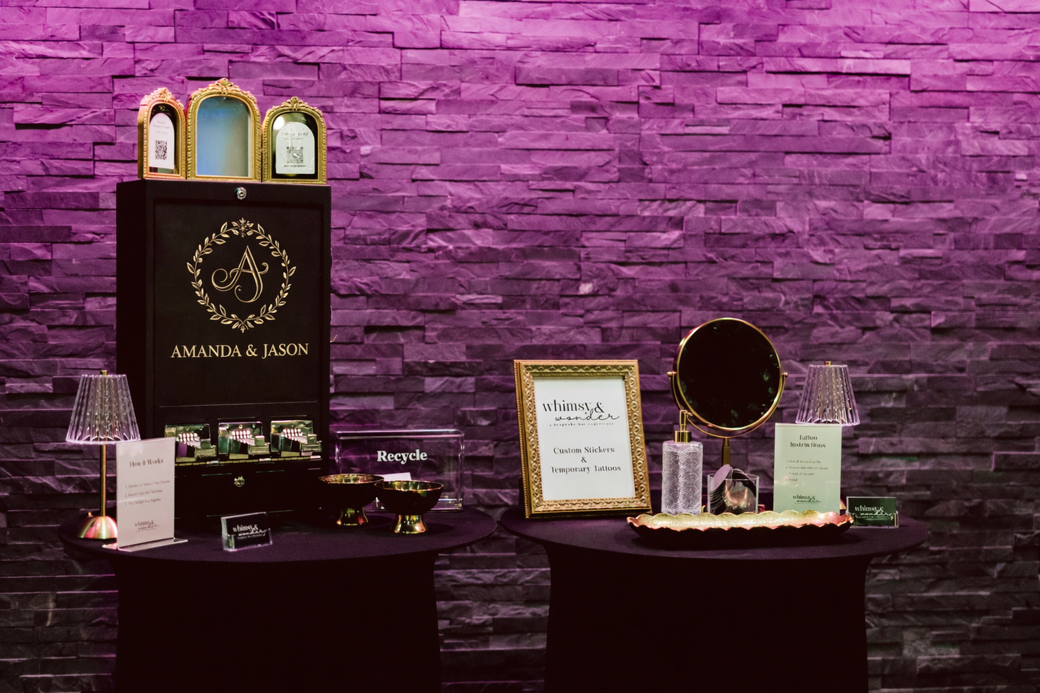 Event display tables with awards and promotional materials against a purple-lit stone wall backdrop.