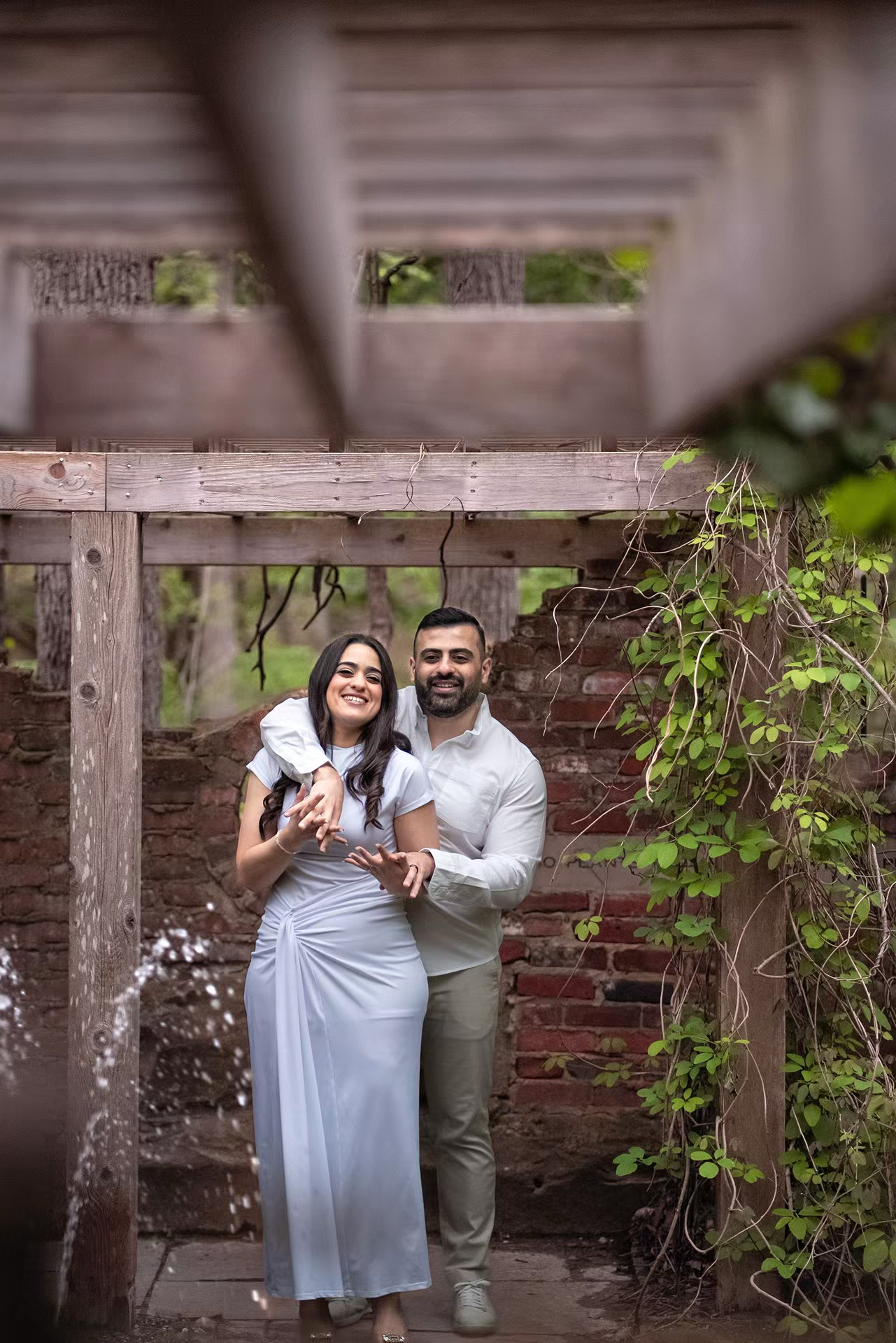 engaged couple shares a romantic moment under a rustic wooden pergola at Inniswood Metro Gardens for their Engagement Photo