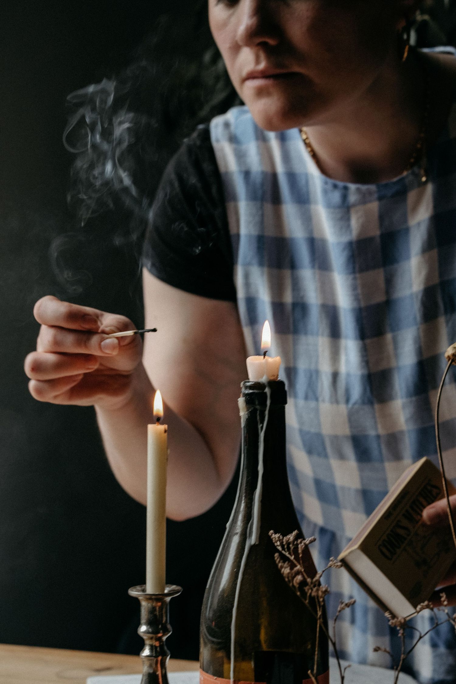 A person in a checked shirt holding a steaming drink, captured in a warm and atmospheric lifestyle brand photography session.