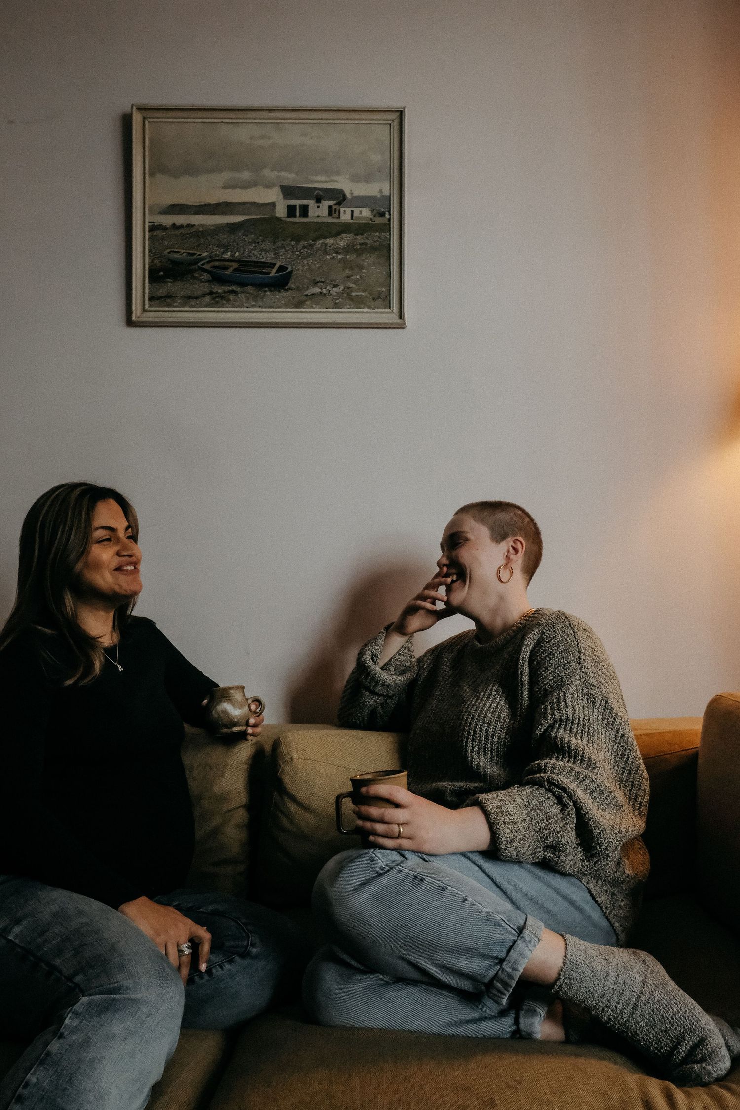 Two people sitting together on the floor in relaxed conversation, captured in a natural and candid lifestyle brand photography session.