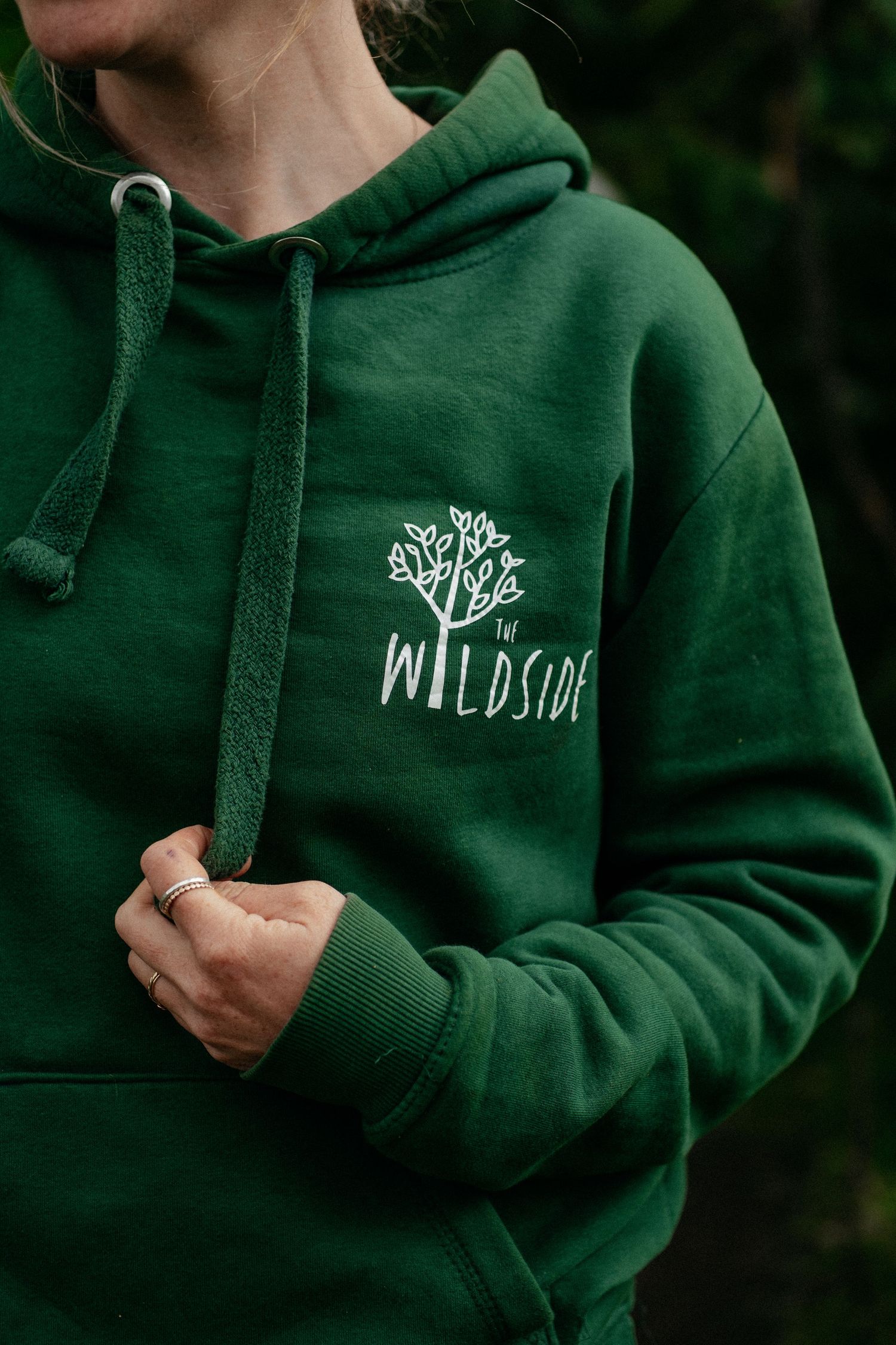 Woman holding the toggle of her brand merchandise hoodie