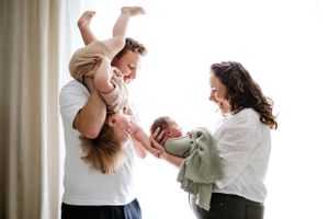 Two people in white shirts share a joyful moment together while playing and laughing at home during family photoshoot in Nottingham