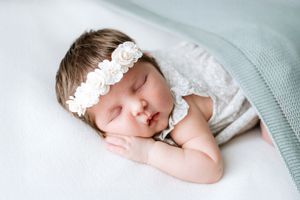 A sleeping baby wrapped in soft bamboo blanket at newborn photoshoot in nottinghamshire studio