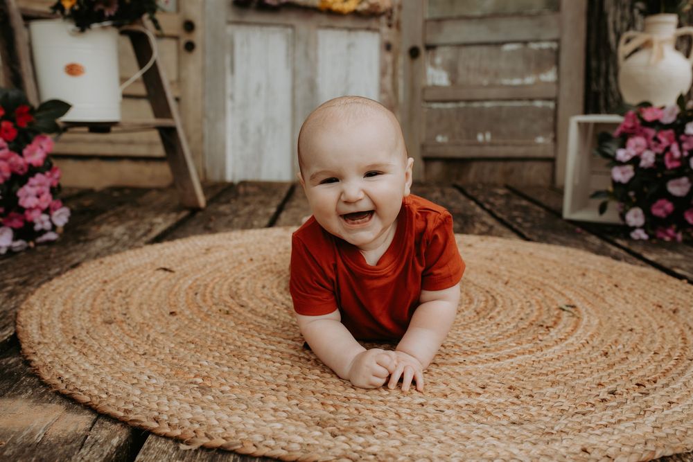 Happy moments captured on a round woven rug in warm natural light.