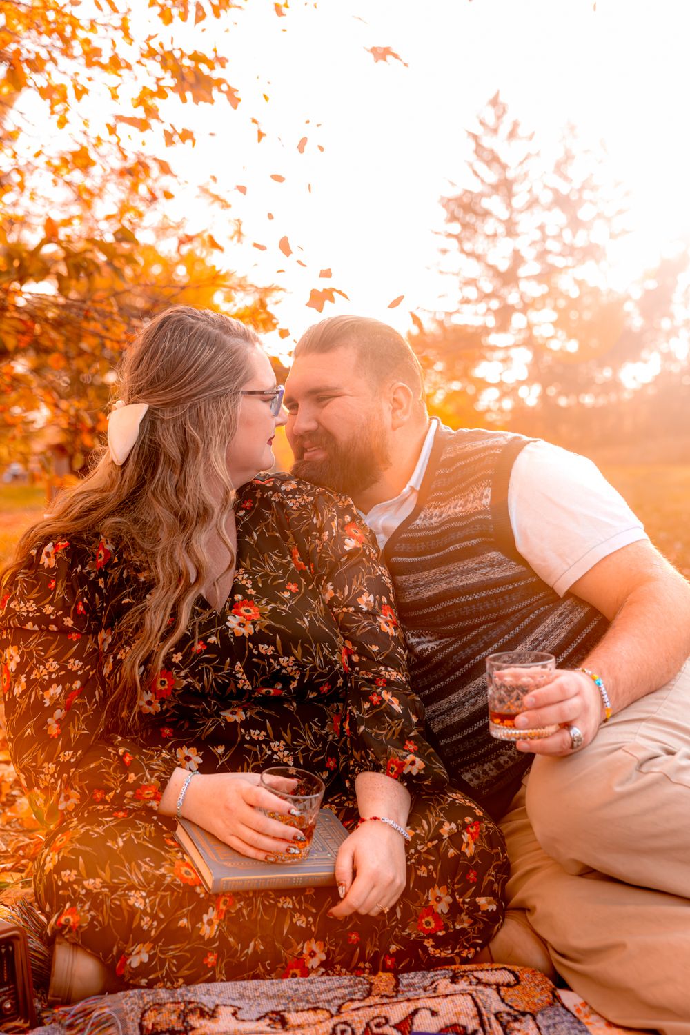 Romantic autumn outdoor photo shoot with warm golden sunlight filtering through orange fall foliage.