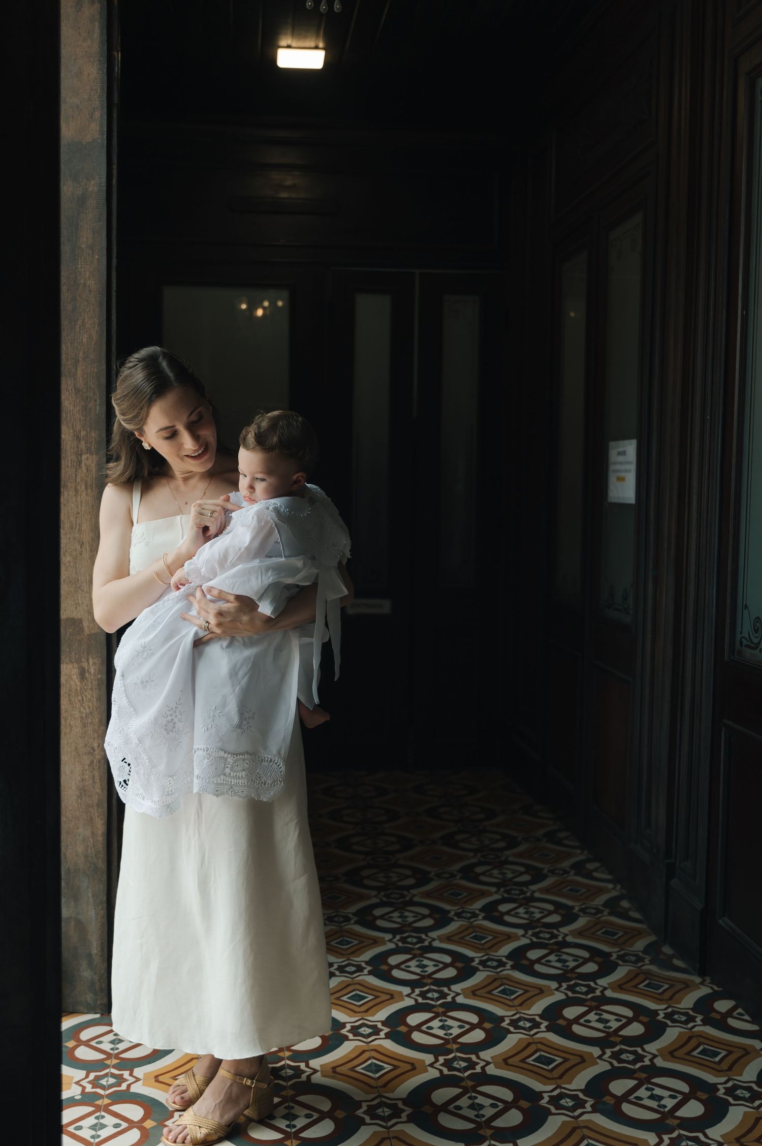 A quiet moment in a dimly lit hallway with decorative floor tiles.