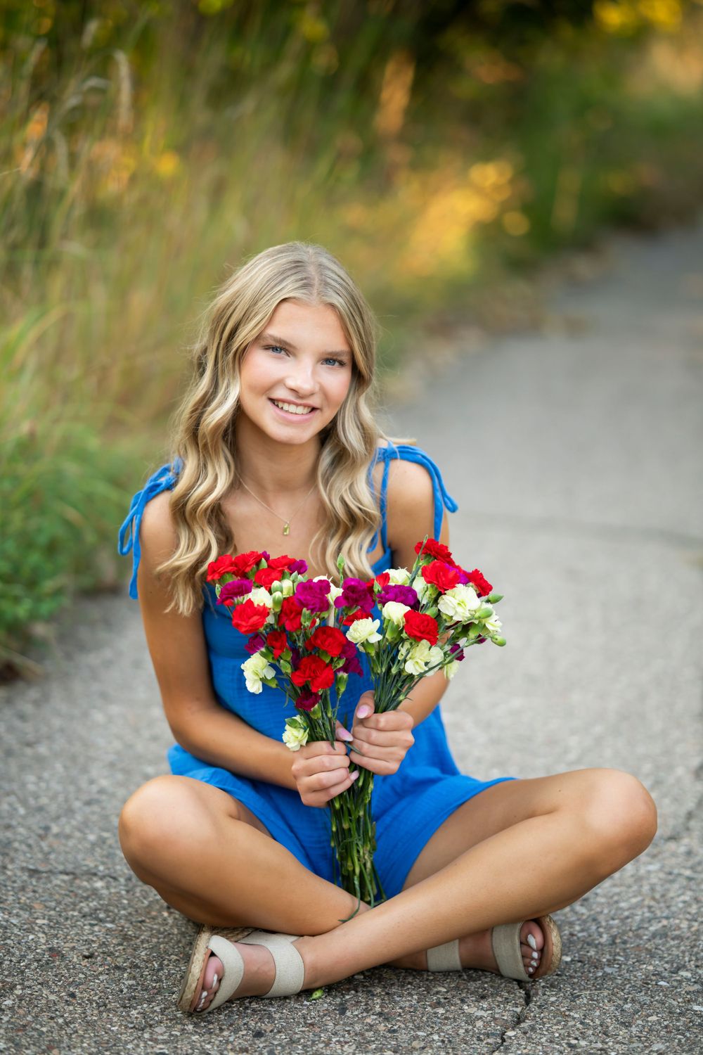 Casual outdoor portraits with red and white flowers on gravel path.