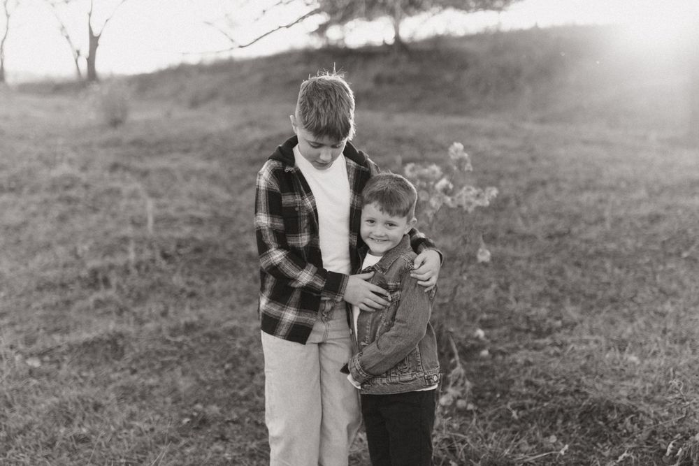 Black and white portrait of two people outdoors in plaid and casual wear.