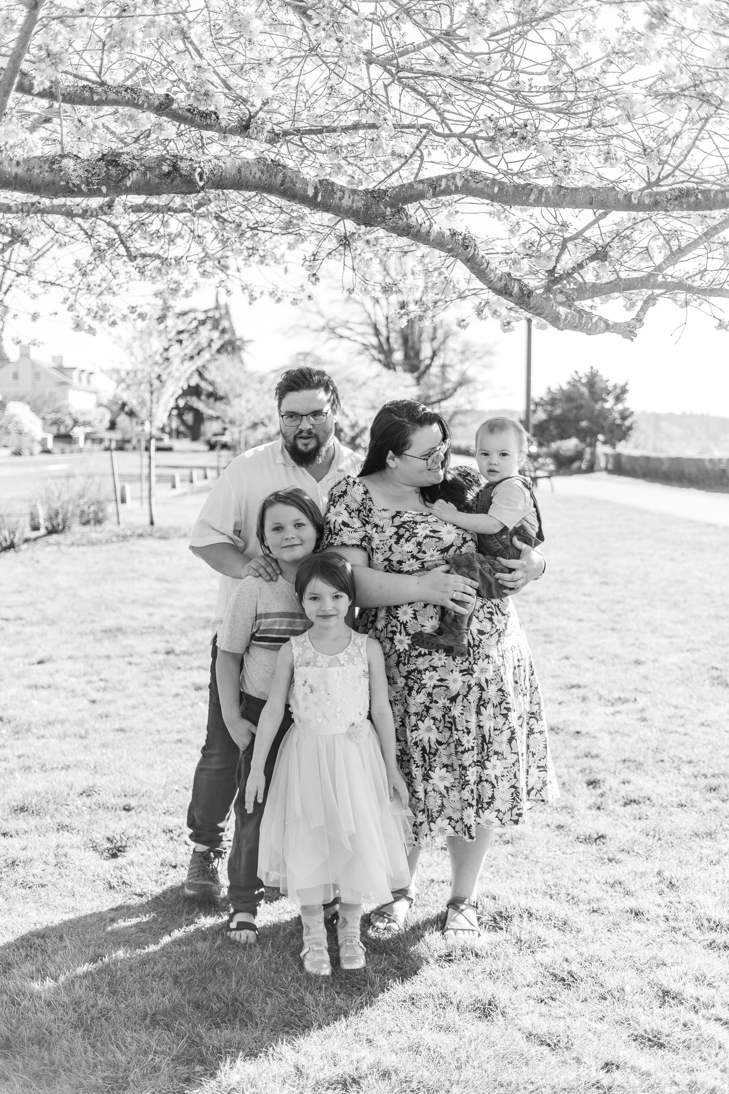 Family portrait under blooming spring trees in black and white.