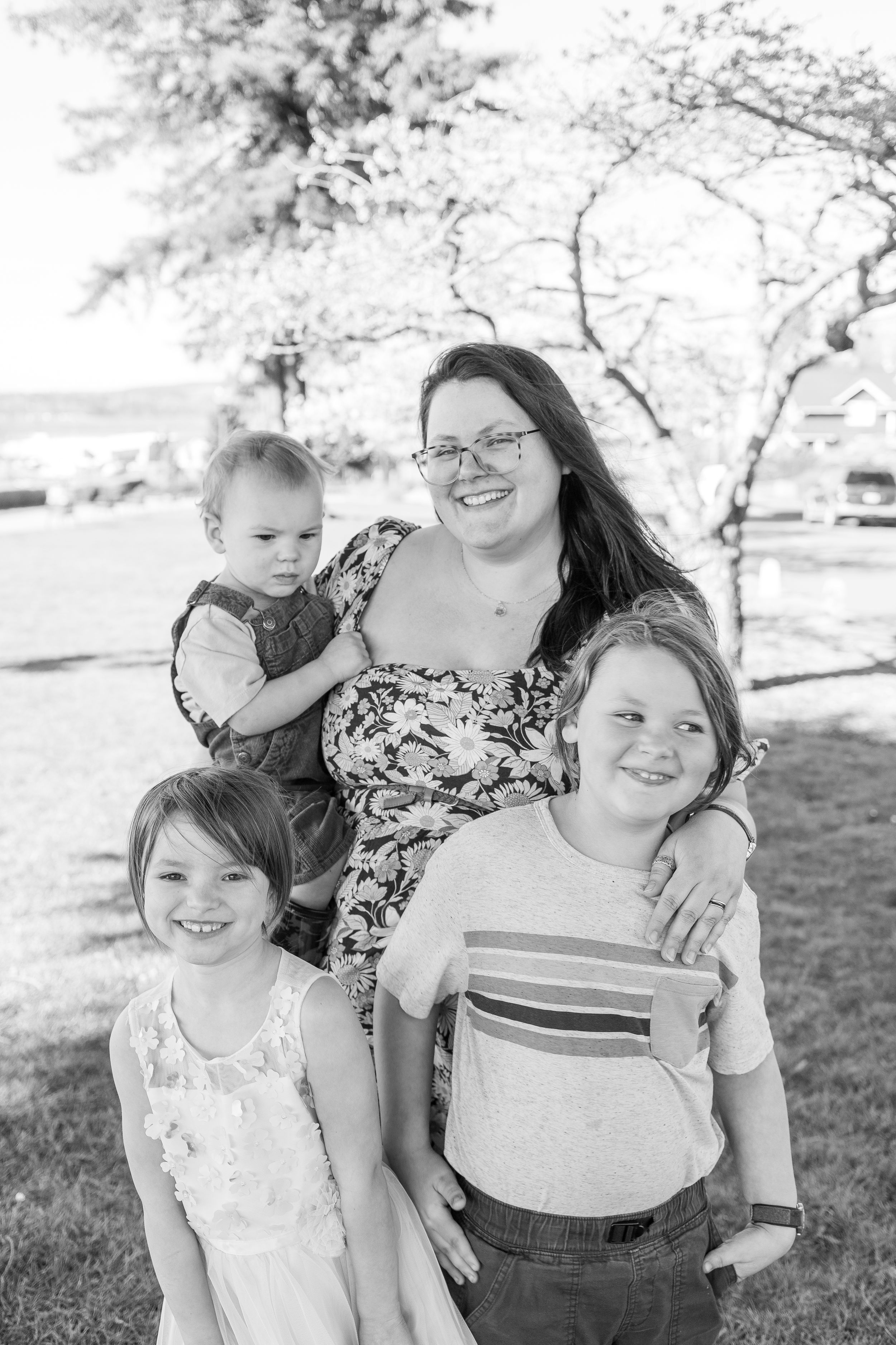 Black and white portrait of a family group under spring trees.