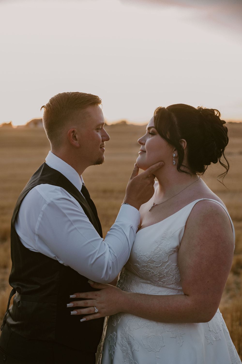Intimate moment between couple during golden hour in rural setting.