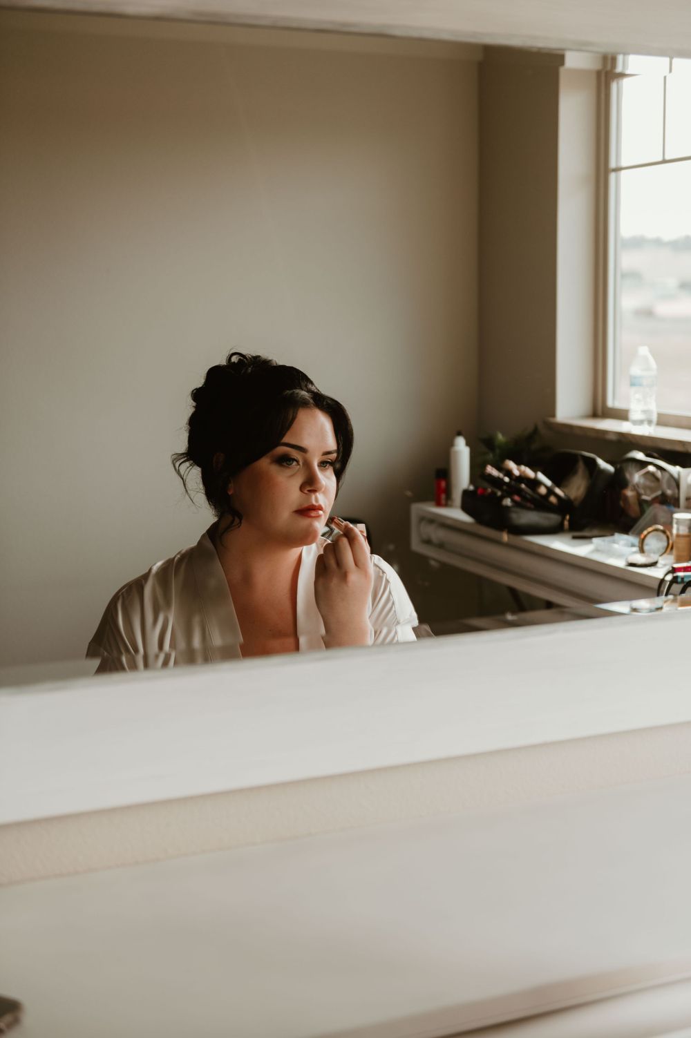 Getting ready scene in natural window light with soft neutral tones.