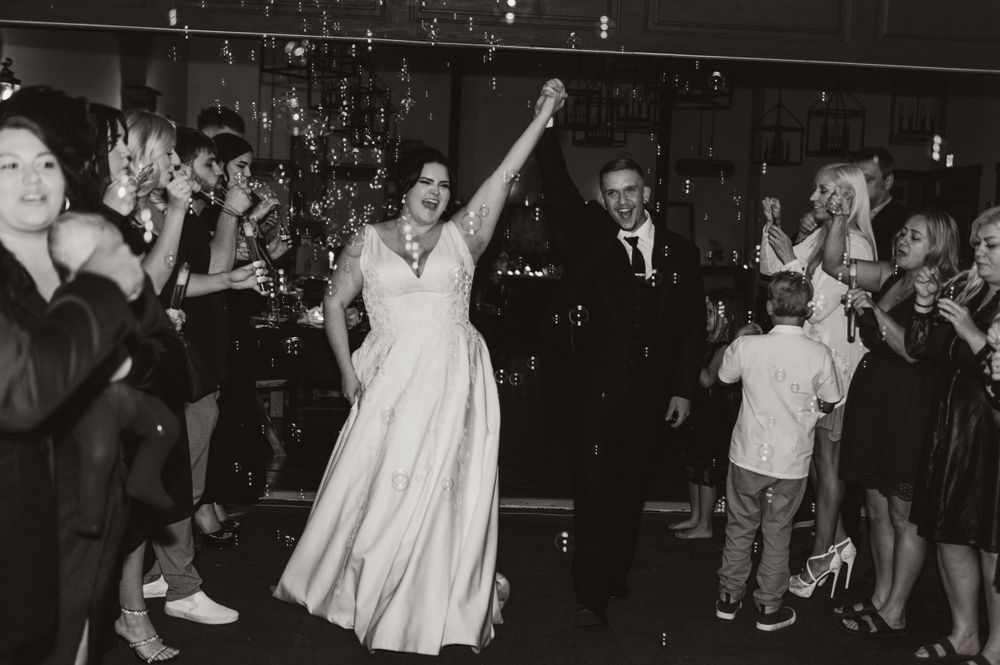 Wedding celebration with dancers on a dark dance floor under twinkling lights.