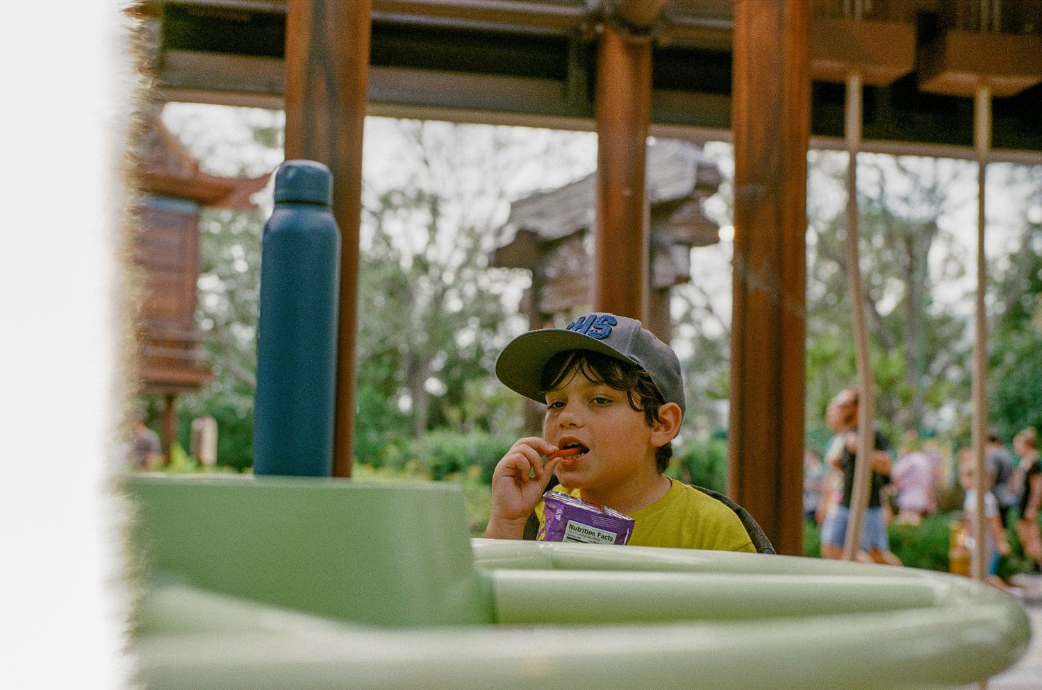 Young visitor wearing baseball cap at theme park attraction.