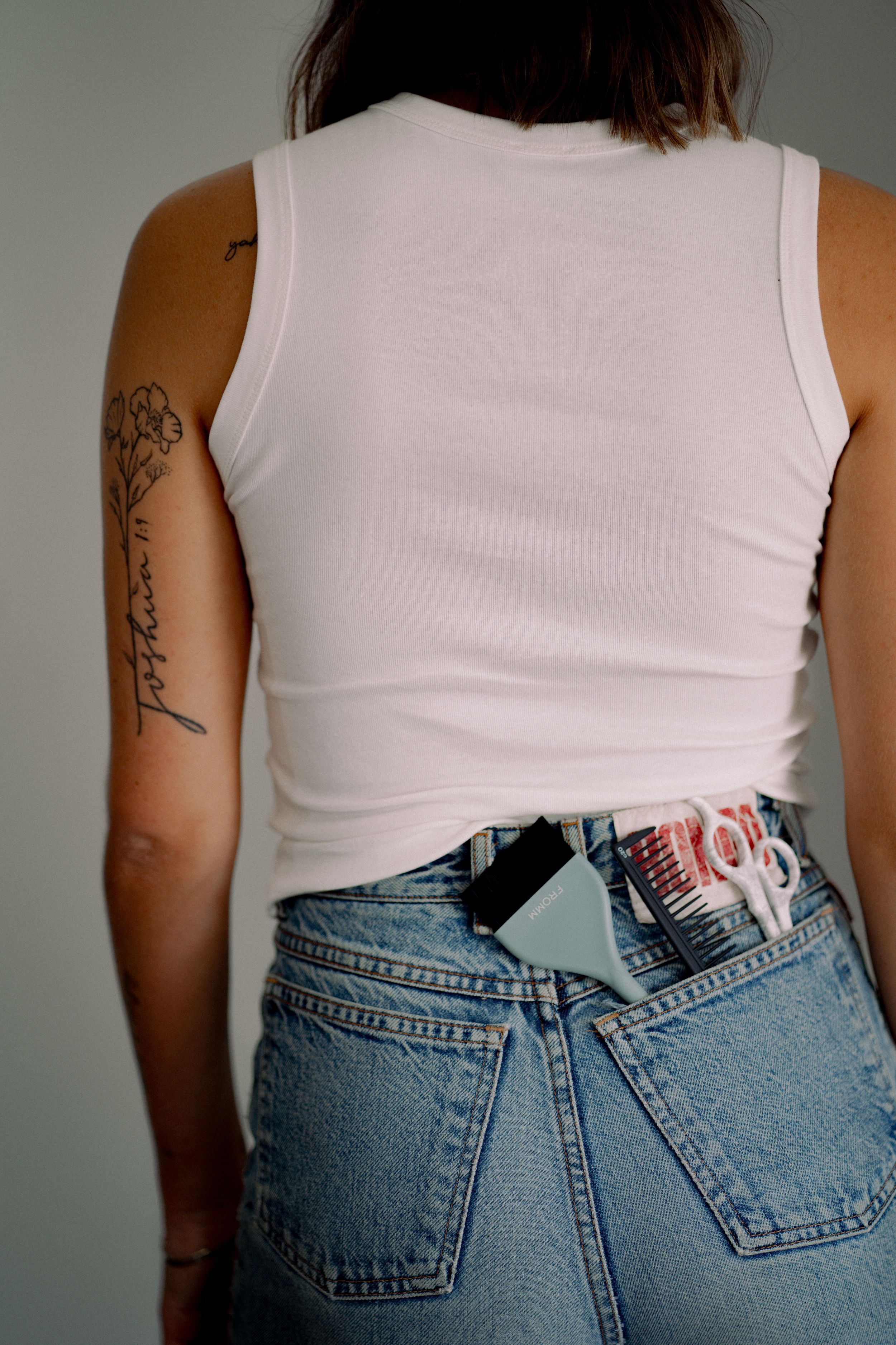 A series of photos showing vintage high-waisted denim jeans from different angles with a white tank top.