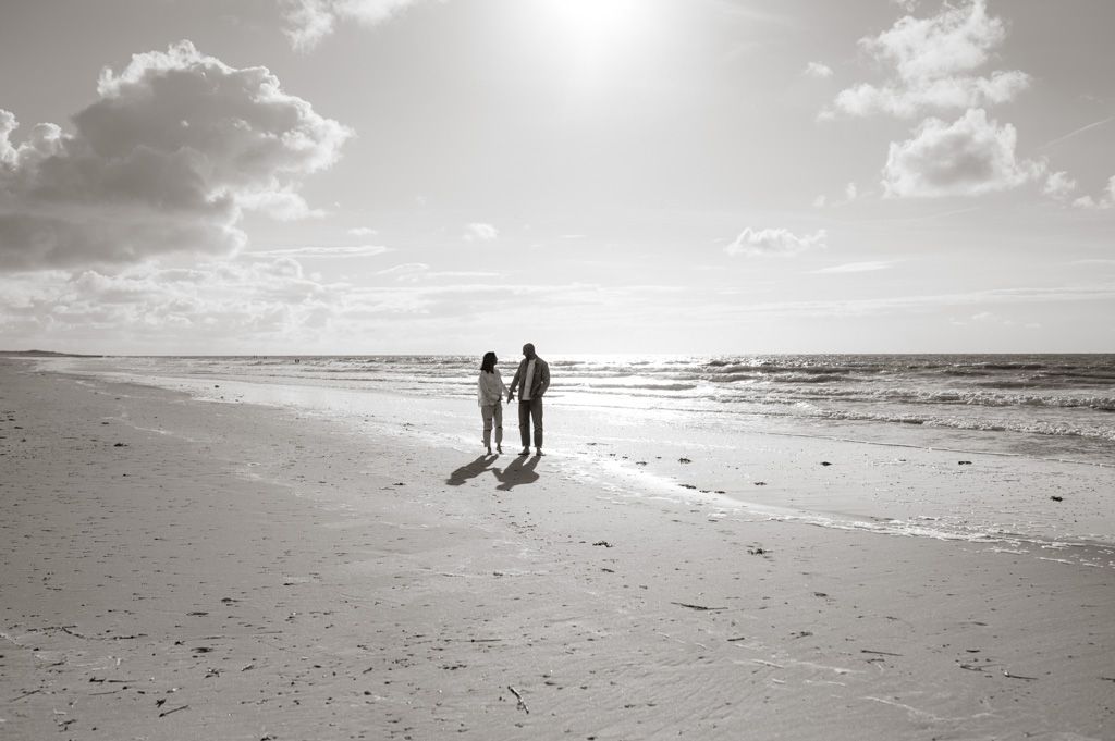 Melissa Stuer Photography Moederschapsfotograaf Moerbeke Zwangerschapsfotograaf koppel die handen vasthouden wandelend op het strand aan zee