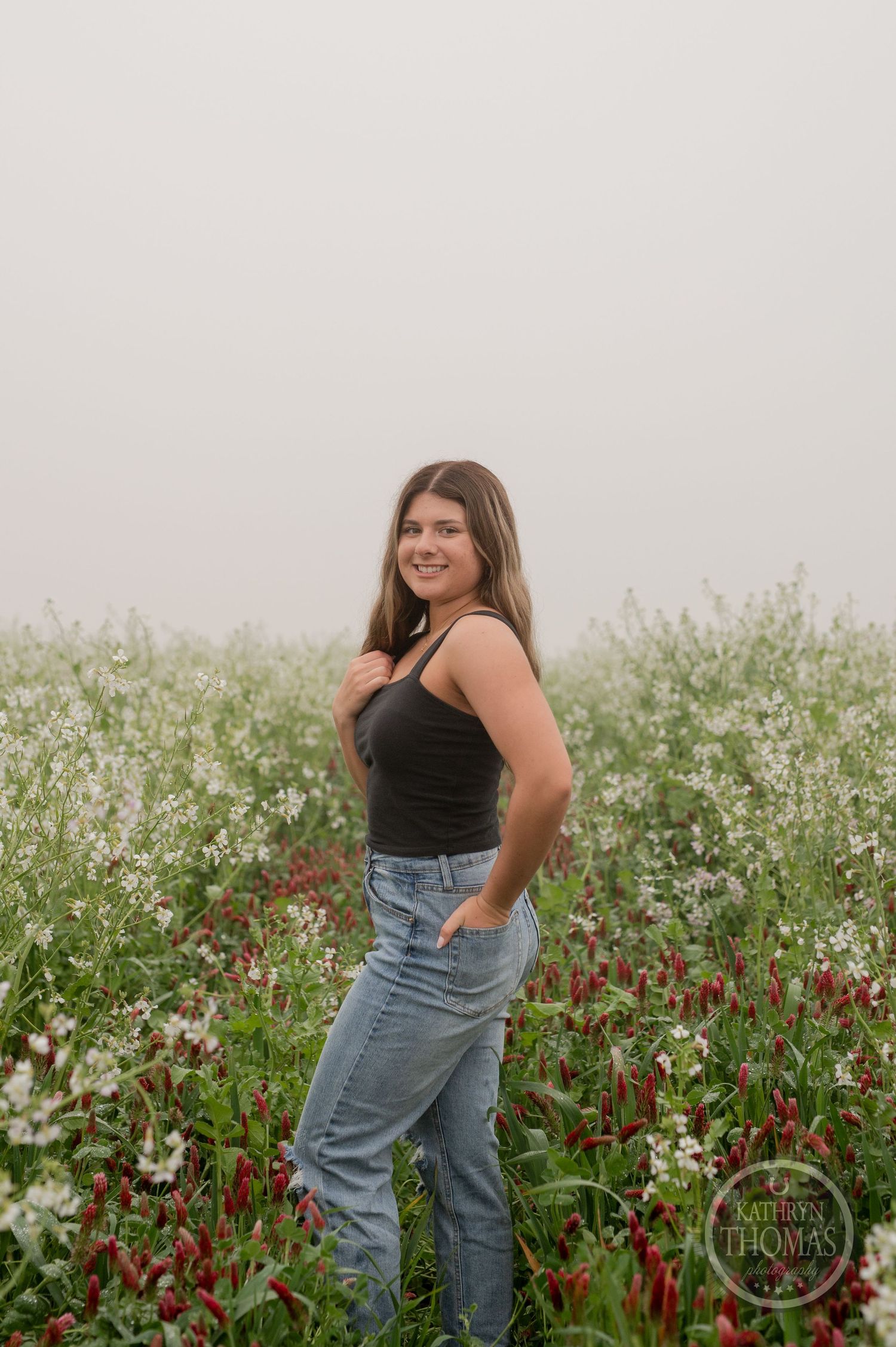 Stylish casual outfit photographed against a backdrop of white wildflowers and natural foliage.