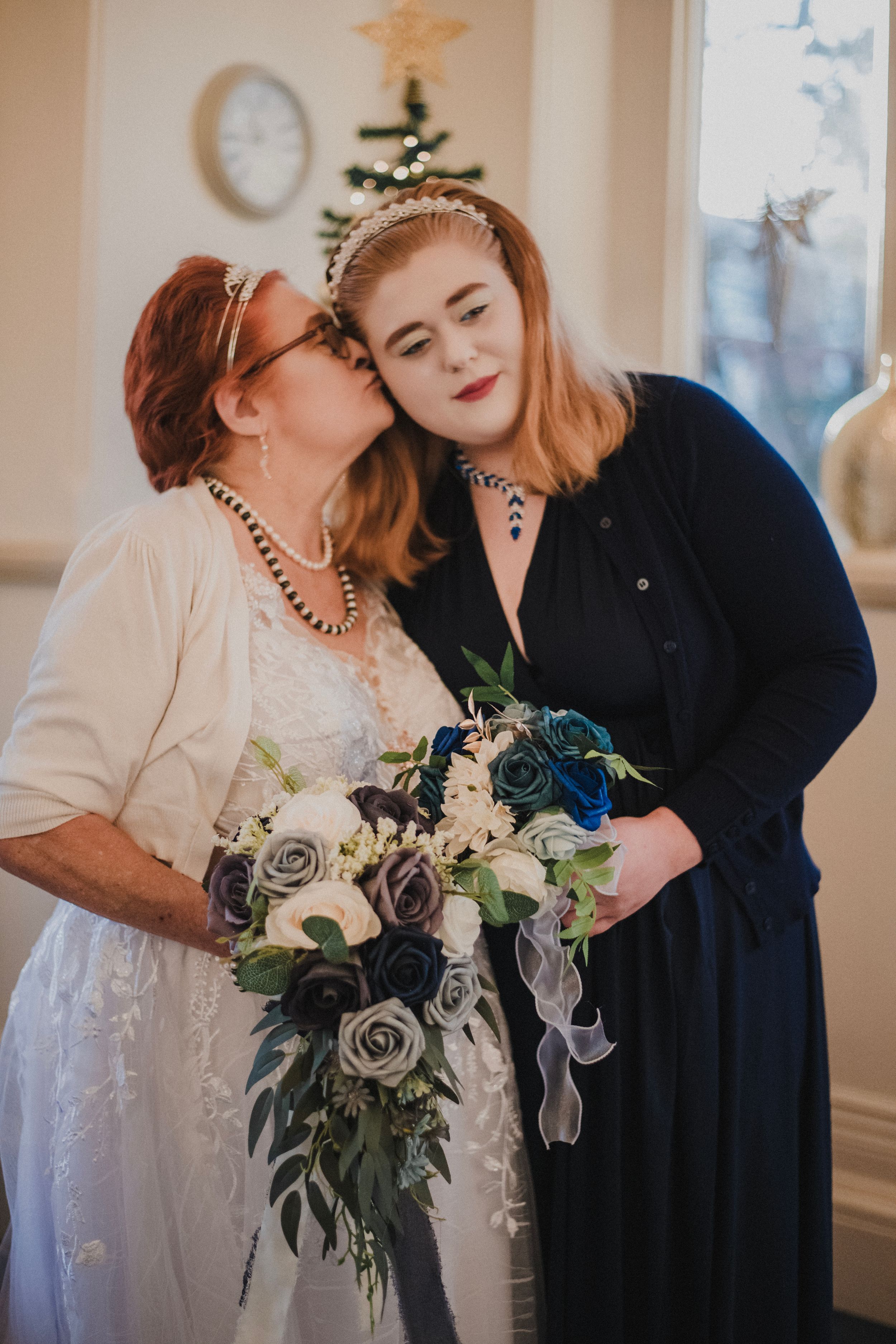 Intimate wedding moment with two participants sharing a tender moment while holding a blue and white bouquet.