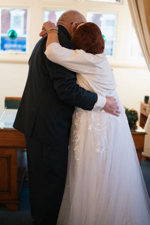 Wedding couple embraces in tender moment during their ceremony.