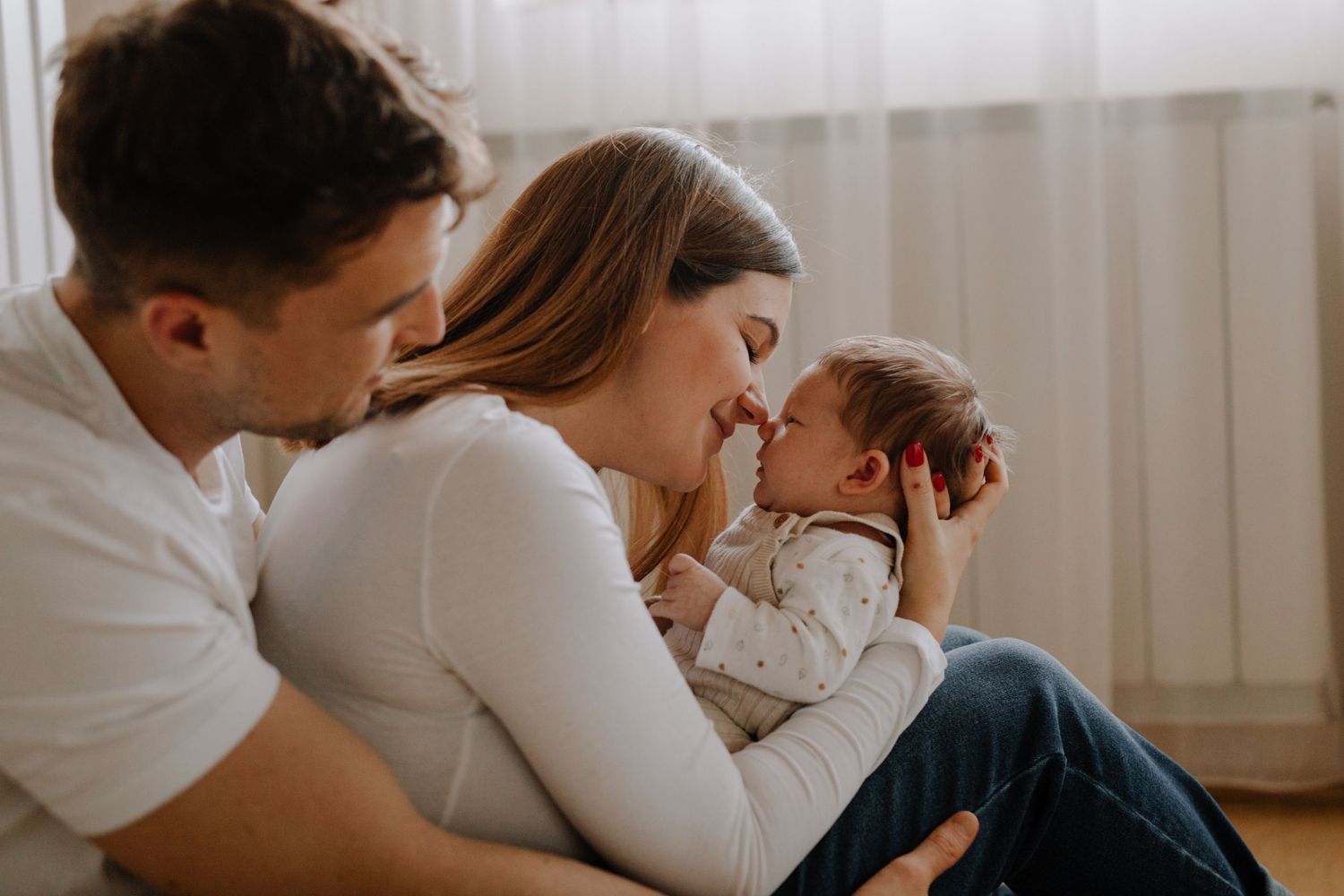Intimate family moment together in a bright sunlit room.