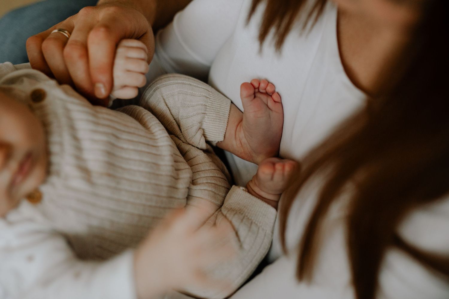 Close up of tiny baby feet and hands during an intimate family moment.