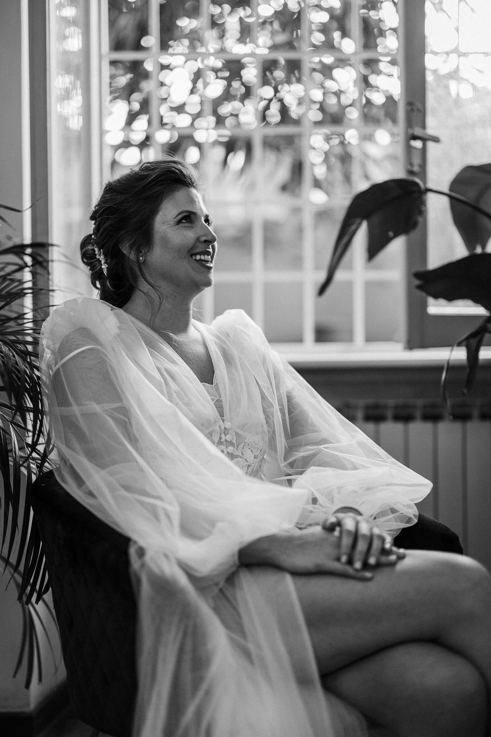 Black and white candid shots of a bride laughing in a sunlit room.