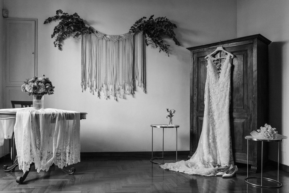 Wide panoramic view of a bridal preparation room with dresses and decor.