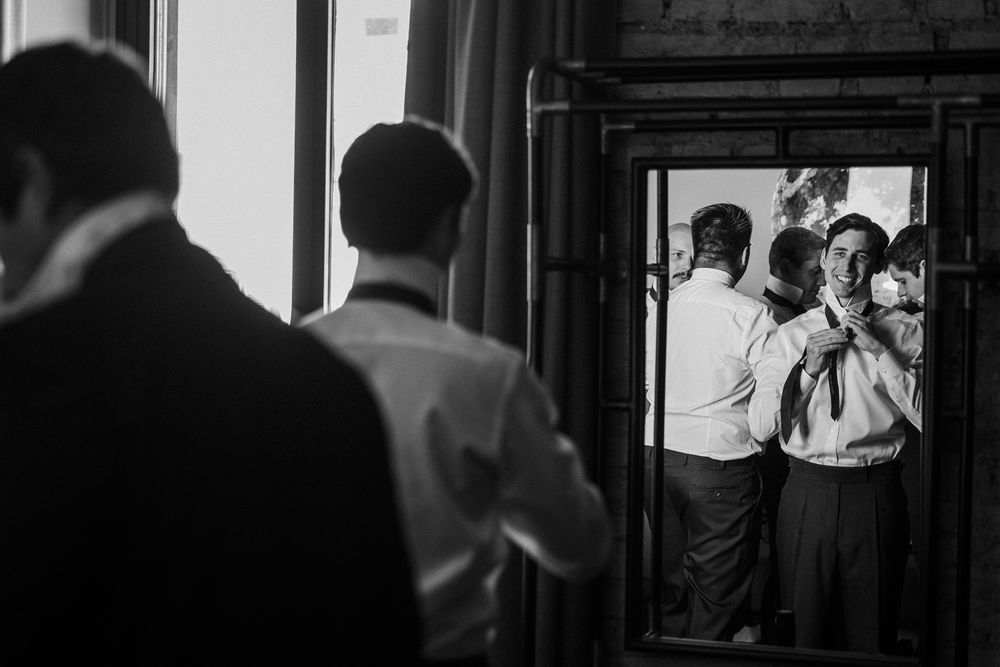 Wedding party silhouettes captured through doorways and windows in dramatic black and white photography.