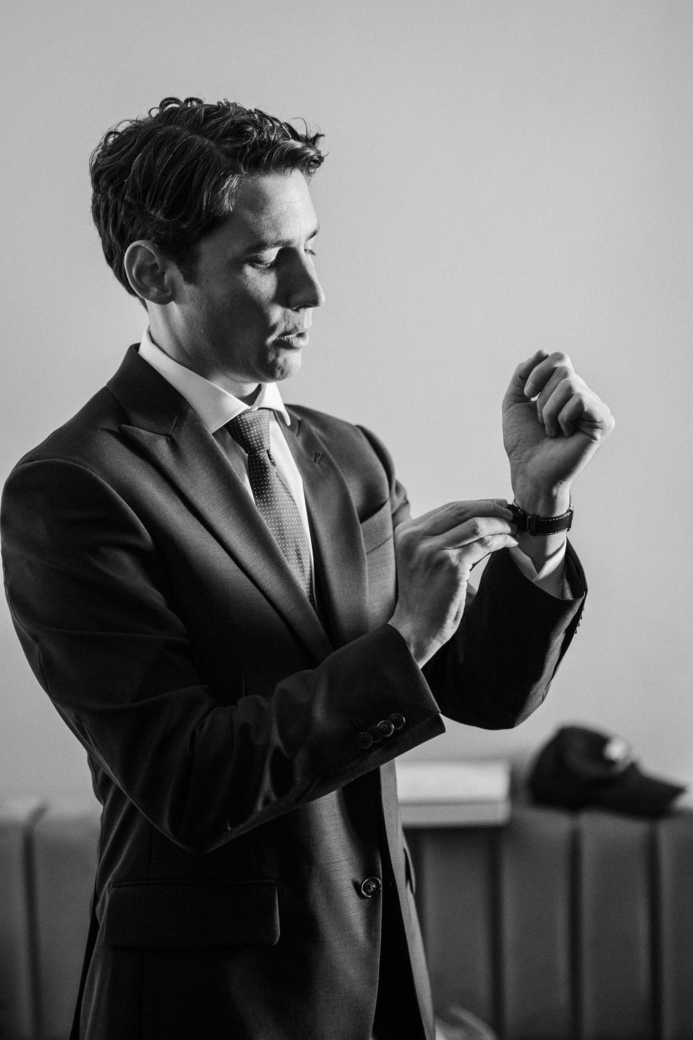 Sequence showing someone adjusting their formal attire in stylish black and white portraits.
