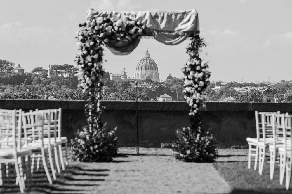 Scenic rooftop wedding venue with white chairs and city views in the background.