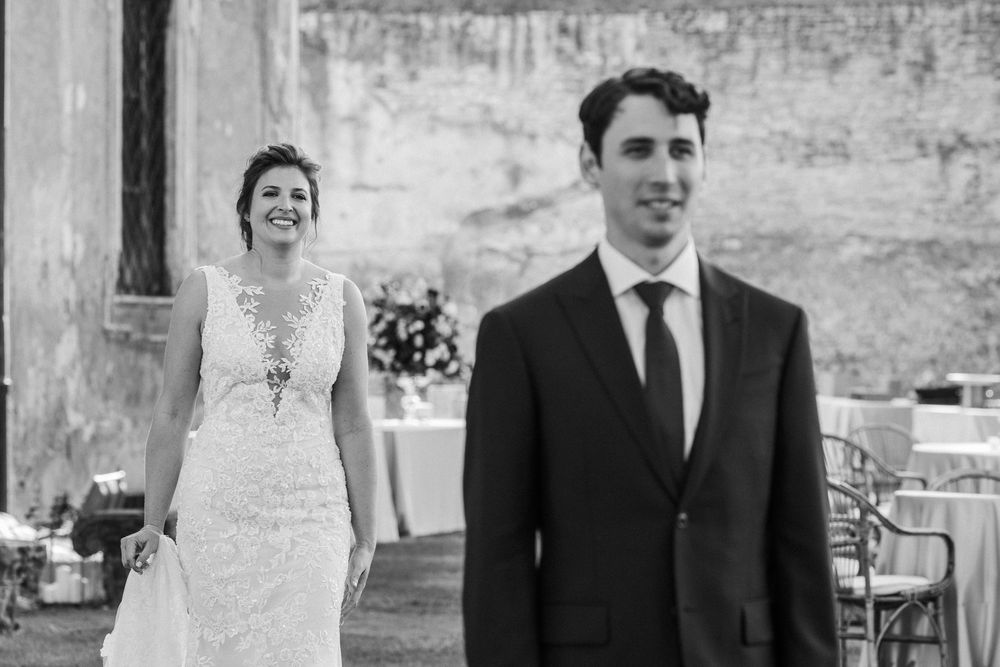 Wedding couple portraits against rustic stone walls in classic black and white photography.